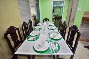 einen langen Tisch mit Stühlen, Tellern und Besteck in der Unterkunft Emerald Island Hotel in Boracay