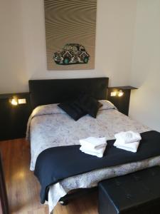 1 dormitorio con 1 cama con 2 toallas en Megaride Guest House, en Como