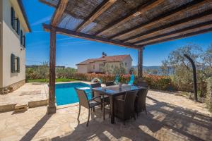 a patio with a table and chairs and a swimming pool at Holiday house BRZAC in Brzac