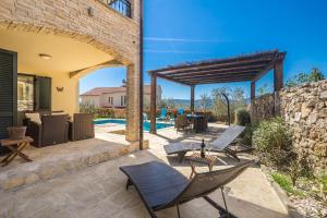 a patio with chairs and a stone wall at Holiday house BRZAC in Brzac +25 photos