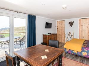a living room with a table and a bedroom at Haka Lodge in Aberystwyth