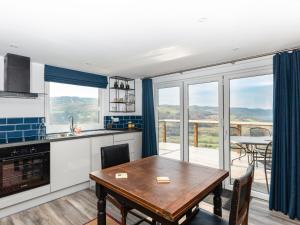a kitchen with a table and a view of a balcony at Haka Lodge in Aberystwyth