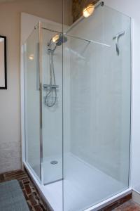 a shower with a glass door in a bathroom at The Barn at Amberwell in Ditcheat