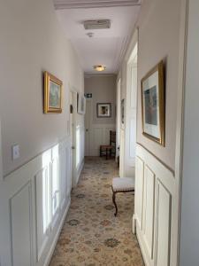 a hallway with white walls and a chair in a room at Port Charlotte Hotel in Port Charlotte