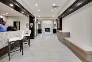 a man standing at a counter in a lobby with a fireplace at Staybridge Suites - Oklahoma City - Downtown, an IHG Hotel in Oklahoma City