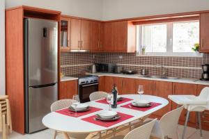 a kitchen with a white table and a refrigerator at Angel-kolymvari4you in Kolymvari