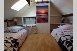 a bedroom with two beds and a painting on the wall at Charming flat middle of Trouville, 150m from beach in Trouville-sur-Mer