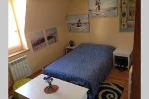 Un dormitorio con una cama azul y una mesa en Charming flat middle of Trouville, 150m from beach en Trouville-sur-Mer
