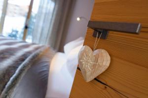 un corazón de madera colgando de una puerta en un dormitorio en Haus Haro en Zermatt
