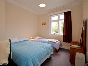 um quarto com 2 camas e uma janela em St Marys Vicarage Retreat - Raetihi Holiday Home em Raetihi