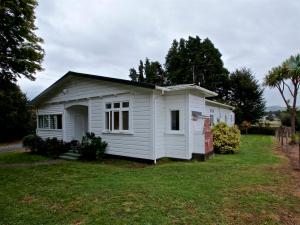 uma pequena casa branca num quintal em St Marys Vicarage Retreat - Raetihi Holiday Home em Raetihi