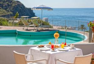 a table with food on it next to a pool at Hotel San Giorgio Terme in Ischia