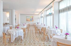 a dining room with tables and chairs with white tablecloths at Hotel San Giorgio Terme in Ischia