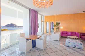 a dining room with a table and chairs and the ocean at Hotel San Giorgio Terme in Ischia