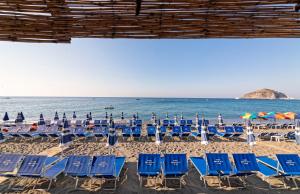 a group of chairs and umbrellas on a beach at Hotel San Giorgio Terme in Ischia