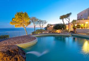 a swimming pool with the ocean in the background at Hotel San Giorgio Terme in Ischia