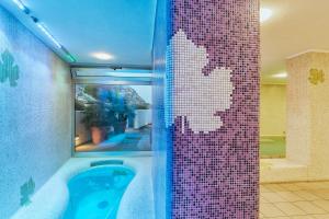 a bathroom with a shower with a tile wall at Hotel San Giorgio Terme in Ischia