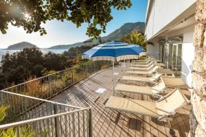 a row of chairs and an umbrella on a balcony at Hotel San Giorgio Terme in Ischia