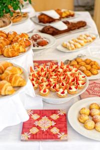 a table topped with plates of pastries and pies at Hotel San Giorgio Terme in Ischia