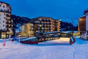 a resort in the snow with a building in the background at Hôtel Le Montana in La Tania