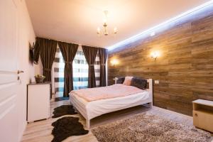 - une chambre avec un lit et un mur en bois dans l'établissement Apartament Maria, à Alba Iulia