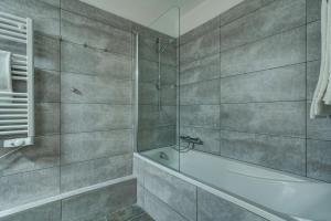 a bathroom with a shower and a bath tub at Hôtel Le Montana in La Tania
