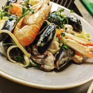 a plate of food with seafood and vegetables on a table at Port Charlotte Hotel in Port Charlotte