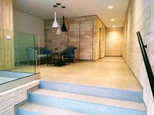 eine Lobby mit Treppen, einem Tisch und Stühlen in der Unterkunft Sweet Home Las Canteras in Las Palmas de Gran Canaria