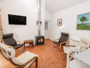 a living room with a fireplace and chairs at Y Buarth in Caernarfon