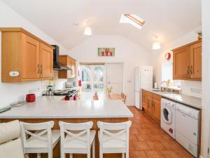 a kitchen with white appliances and wooden cabinets at Y Buarth in Caernarfon