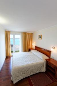 sypialnia z łóżkiem i widokiem na ocean w obiekcie Hotel Val All Inclusive w Trogirze