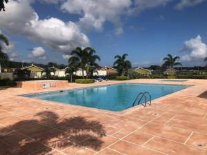a swimming pool in a yard with palm trees at Sweet Holiday Haven in Ocho Rios