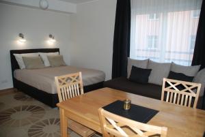 um quarto com uma cama, uma mesa e um sofá em Maria Apartments em Tartu