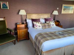 a hotel room with a bed and a chair at Port Charlotte Hotel in Port Charlotte