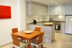 cocina con mesa de madera, sillas y encimera en Apartamento Laurel, en Lloret de Mar