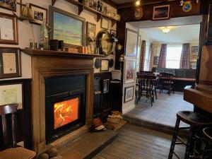 a living room with a fireplace and a dining room at Port Charlotte Hotel in Port Charlotte