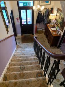 a staircase in a house with a door and a stair railing at Port Charlotte Hotel in Port Charlotte