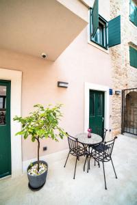 eine Terrasse mit einem Tisch, Stühlen und einem Baum in der Unterkunft Apartments Korta in Split