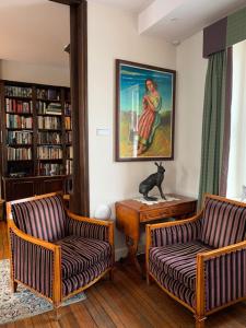 a living room with two chairs and a cat sitting on a table at Port Charlotte Hotel in Port Charlotte