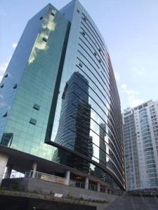 un edificio alto de cristal en una ciudad con edificios altos en VISION FLAT PISCINA ACADEMIA GARAGEM ANDAR ALTO - sem café en Brasilia