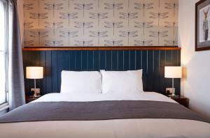 una camera con un grande letto con due lampade di Sun Inn a Eastwood