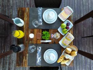 una mesa de madera con platos de comida. en Pousada Retiro das Ilhas, en Bombinhas