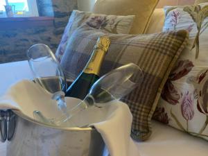 a pair of glasses and a bottle of wine on a couch at Port Charlotte Hotel in Port Charlotte