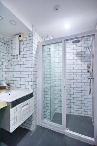 ein Bad mit einer Glasdusche und einem Waschbecken in der Unterkunft Emerald Island Hotel in Boracay