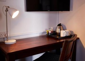 a wooden desk with a lamp and a tray on it at Sun Inn in Eastwood