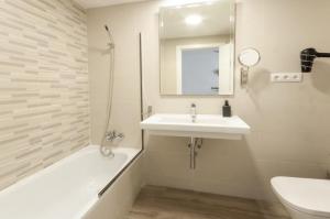 a bathroom with a sink and a tub and a toilet at Thalassa (Gandia) in Gandía