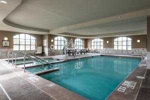 a swimming pool with blue water in a building at Staybridge Suites Eau Claire - Altoona, an IHG Hotel in Altoona