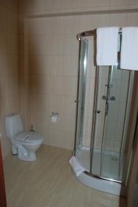 uma casa de banho com um WC e uma cabina de duche em vidro. em Shato Paradis Hotel em Irpin