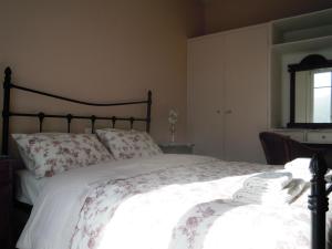 a bedroom with a large bed with white sheets and a window at Blue Dolphin in Batsi