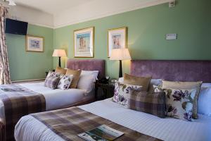 a hotel room with two beds and green walls at Port Charlotte Hotel in Port Charlotte